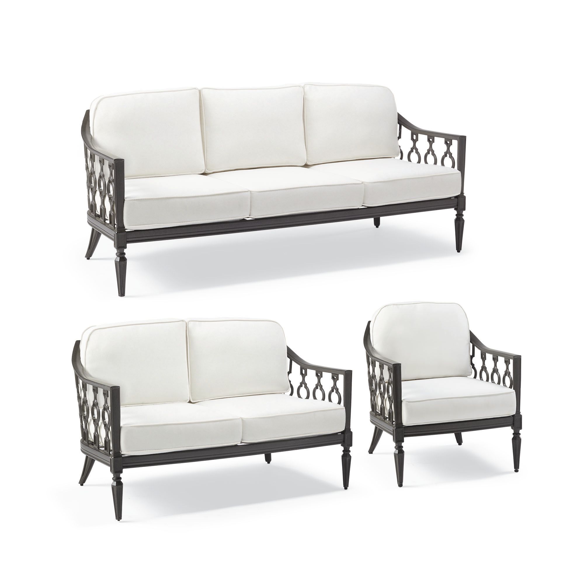A set of tailored white furniture covers on a dark brown outdoor sofa, loveseat, and armchair.