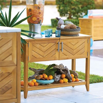 Wooden console table styled outdoors with fruit and drinks.